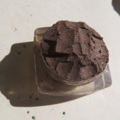 Side view of rich dark brown vegan loose mineral eyeshadow with shimmer pigment in a small jar