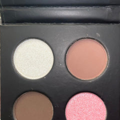 Makeup palette with four round shades in white, peach, brown, and pink colors