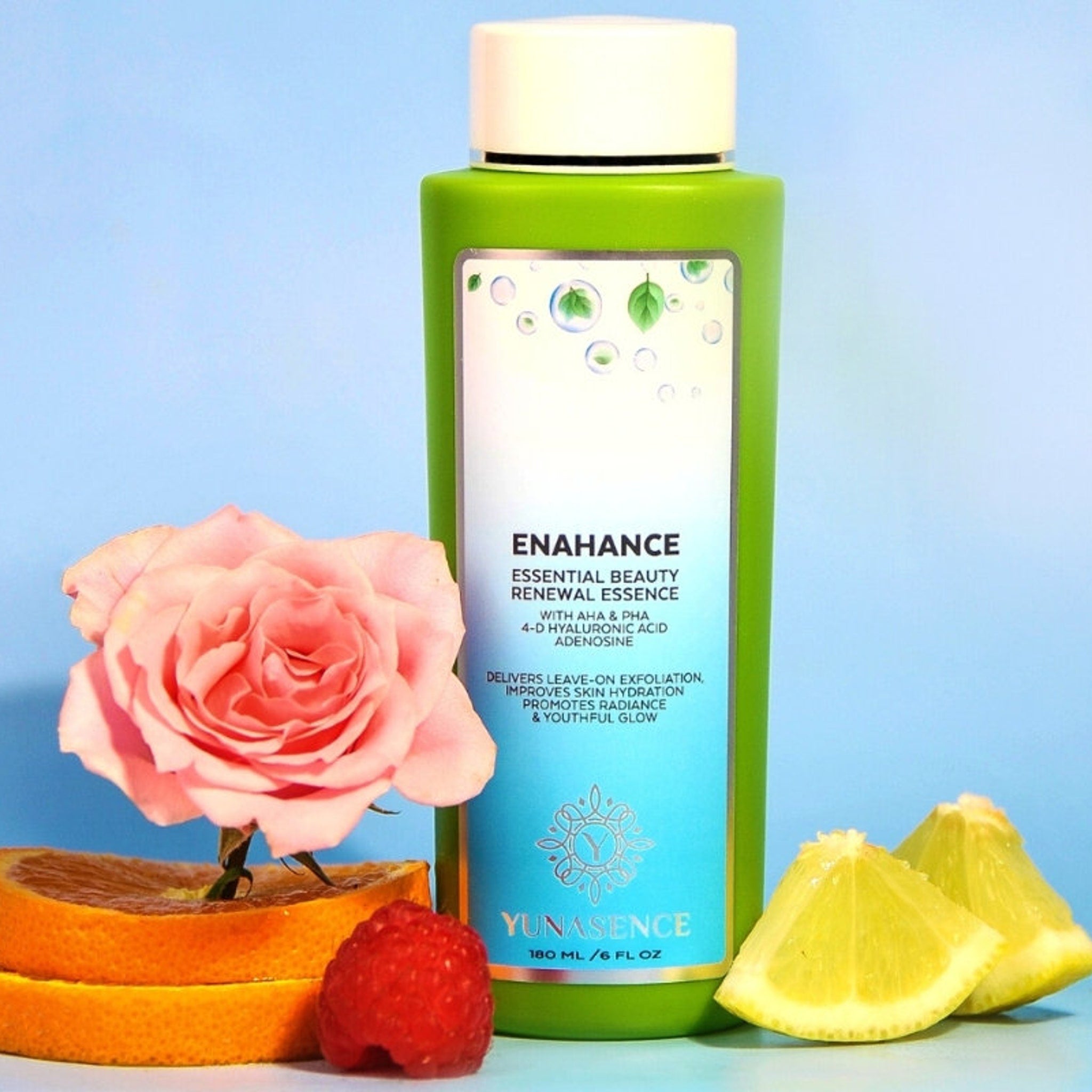 Facial cleanser bottle, green and white, with pink rose and fruit on blue background Yunasence
