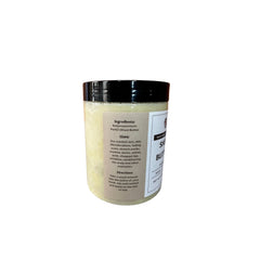 Side view of golden shea butter in glass jar with minimalist label, showcasing rich creamy texture