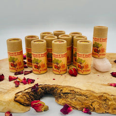 Tinted lip balm tubes in beige cardboard with "Stardust & Stem" text, on wooden surface