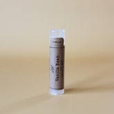 Vanilla Bean lip balm tube with brown label and clear cap, "Vanilla Bean" text visible