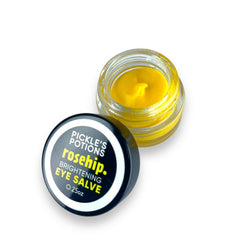 Eye Salve jar with yellow cream, clear glass, and black lid with text "Pickle's Potions Rosehip