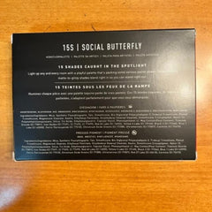 Eyeshadow palette with black packaging, "SOCIAL BUTTERFLY" text, and ingredient list visible