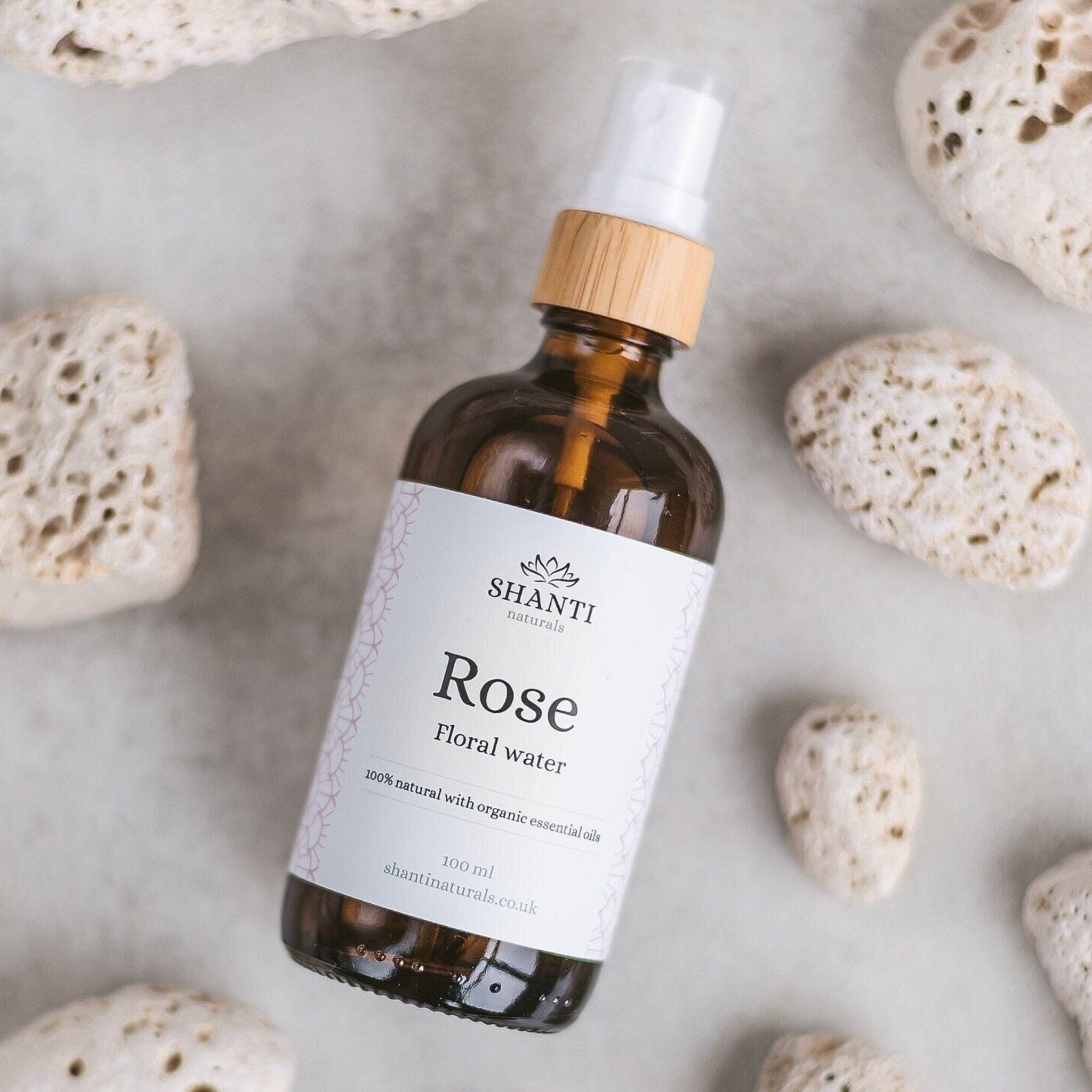 Translucent glass spray bottle of rose and lavender hydrosol toner with minimalist white label