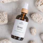 Translucent glass spray bottle of rose and lavender hydrosol toner with minimalist white label