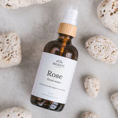 Translucent glass spray bottle of rose and lavender hydrosol toner with minimalist white label