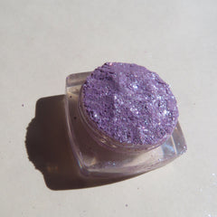 Side view of Winter Violets shimmer eye shadow palette showing sparkling purple and blue glitter texture