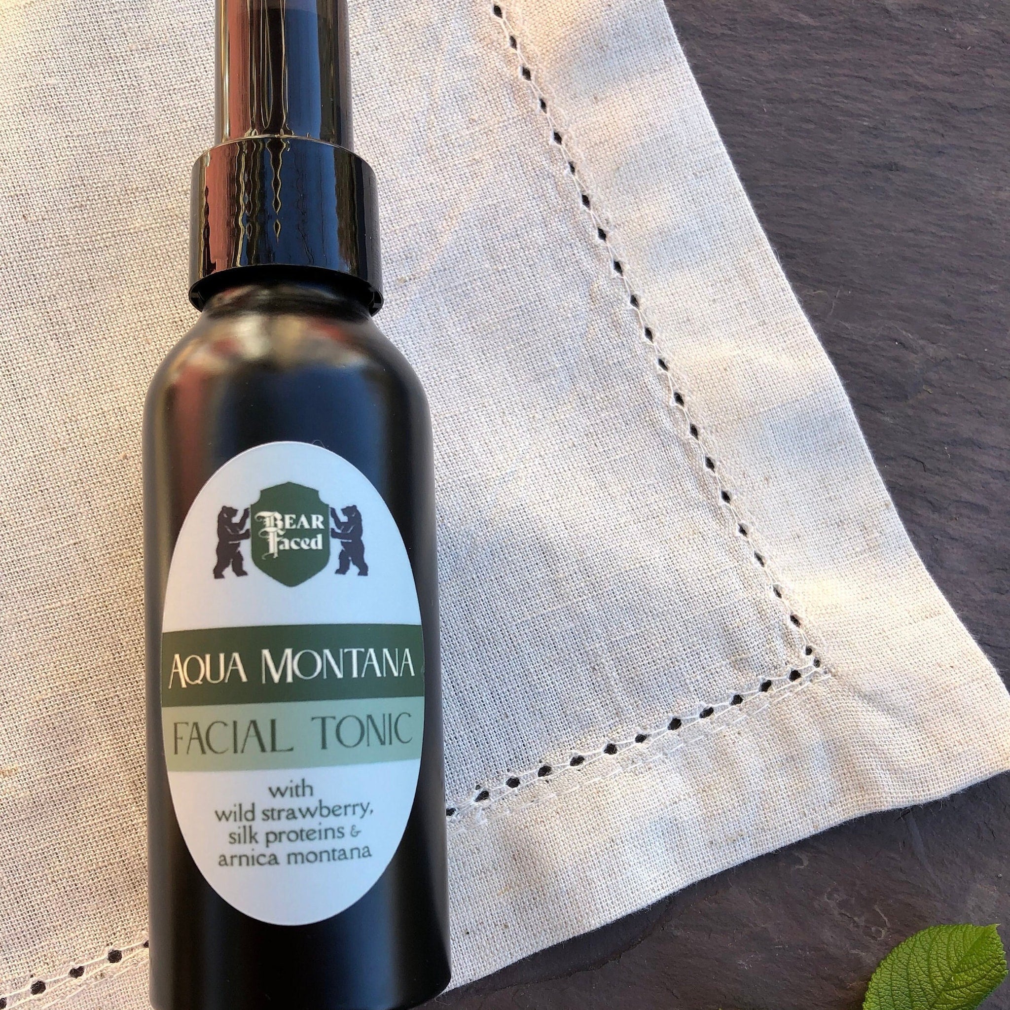 Facial toner bottle, black glass, white label, Bear Faced skincare brand