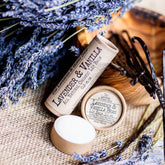 Lip balms, brown cardboard tubes and containers, white balm, lavender and vanilla bean visible
