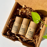 Organic lip balm tubes in brown cardboard box with brown paper filler and green leaf