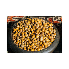 Side view of amber glass jar with gold lid showcasing rich argan butter texture and minimalist branding