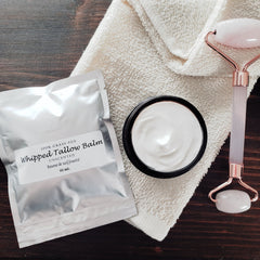 Side view of round amber jar with whipped tallow balm, showcasing creamy texture and minimalist label design