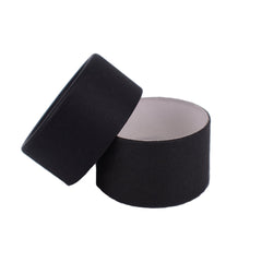 Round black box with a matte finish and a white interior, open lid