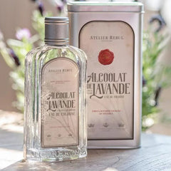 Eau de Cologne bottle, clear glass, silver cap, and Atelier Rebul branding on label and tin