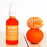 Amber glass dropper bottle of Vitamin C serum with gold cap and minimalist label on marble surface