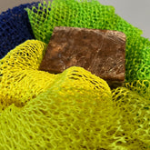 Bar soap with brown block, yellow and green mesh, and blue mesh fabric