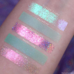 Eyeshadow swatches with pink, green, and iridescent glitter, applied on skin, with text labels Divine Light, Paradise, Earthlight, Awakening, and Moonrise