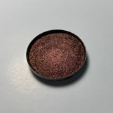 Eyeshadow compact with brown and pink duochrome shimmer, round metal container