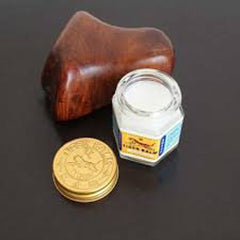 Side view of White Tiger Balm jar with gold lid, showcasing its smooth cream texture and elegant minimalist design.