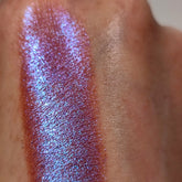 Eye shadow swatch with iridescent purple and blue shimmer on skin