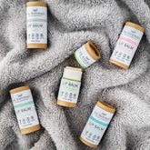 Lip balm tubes with white labels, brown paper tubes, on gray fabric