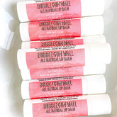 Lip balm tubes with pink label, white tube, and "Bubblegum Wall" text