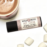Lip balm tube with Wild Rose label, black cap, and light brown wrapping paper