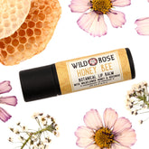 Lip balm tube with black cap and HONEY BEE label, surrounded by flowers and honeycomb