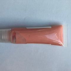 Lip gloss tube with peach color, clear plastic, and white label detail.