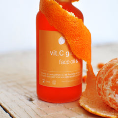 Close-up of golden vitamin C serum with lactic acid, glistening in a glass dropper bottle against soft light