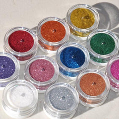 Close-up of glitter eye shadow powder sparkling through sifter lid in small glass jar
