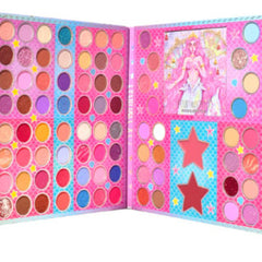 Eyeshadow palette with pink, blue, and brown shades, mermaid and star designs on pink background.