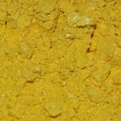 Close-up of mineral eye shadow powder in glass jar with black sifter lid, showing rich pigment texture