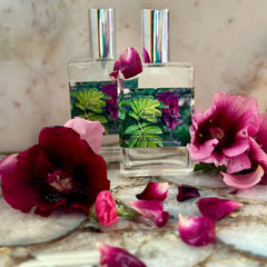 Rose toner bottles with silver caps, pink rose petals, and California Roses Skin Care label