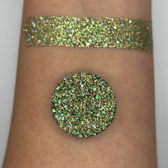 Round Venus pressed glitter eyeshadow in a sleek black compact with mirrored finish, showcasing vibrant shimmer particles