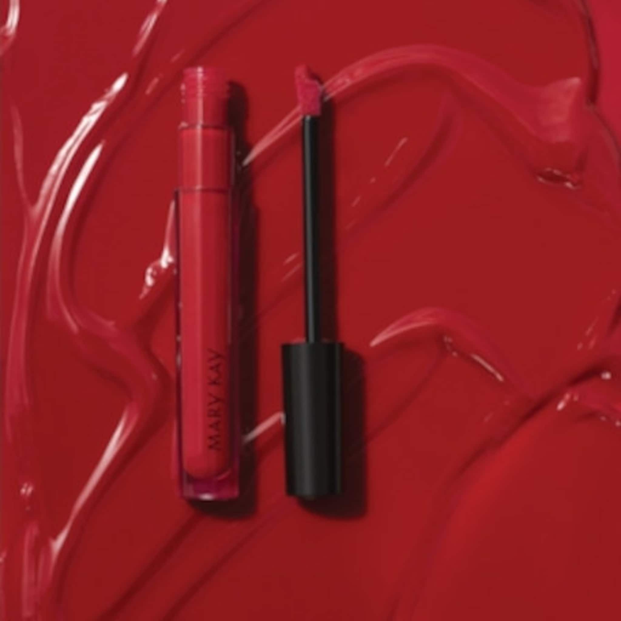 Lip gloss red with black applicator and Mary Kay branding on a red background