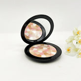 Face powder compact with black case, mirror, and multi-color powder pattern Guerlain
