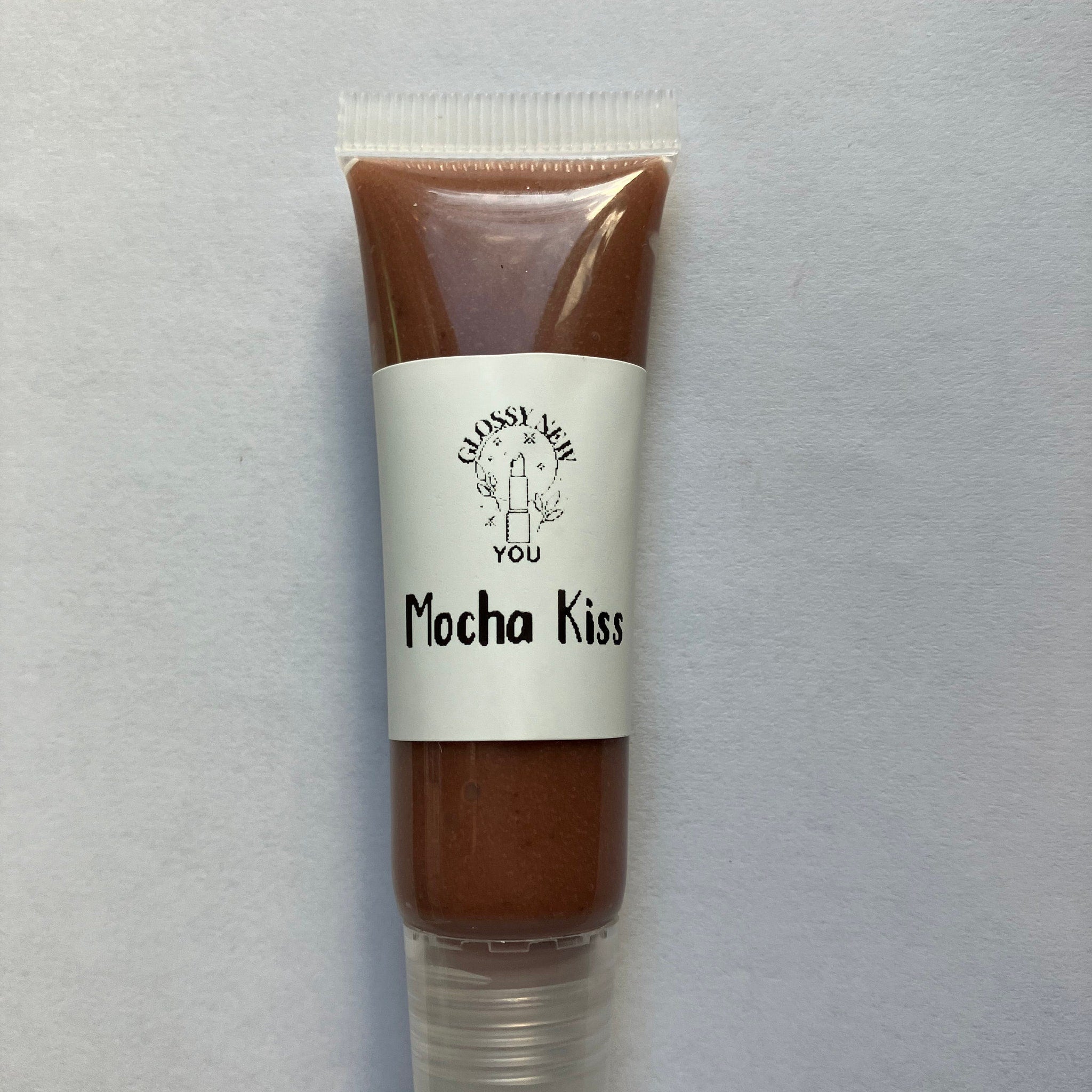 Lip gloss tube with brown gloss, white label, and clear plastic cap, Glossy New You Mocha Kiss