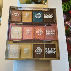 Eyeshadow palettes with various colors, white graphic icons, and E.L.F. DNKN text
