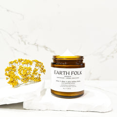 Close-up of rich grass-fed tallow cream in glass jar with olive oil droplets on surface