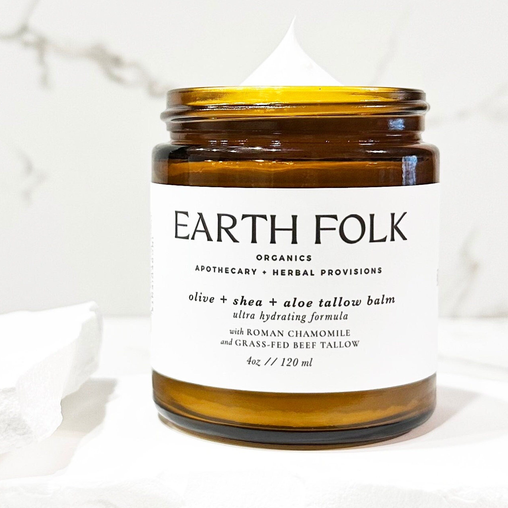 Luxury glass jar of grass-fed tallow moisturizer with olive, shea, and aloe, showcasing rich cream texture