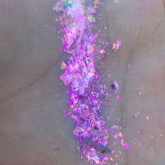 Close-up of fingertips applying shimmering bronze Flakes Eye Shadow to eyelid crease