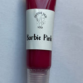 Lip gloss tube with pink liquid, white label, and "Barbie Pink" text