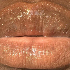 Lip gloss with shimmering gold glitter and glossy finish on lips