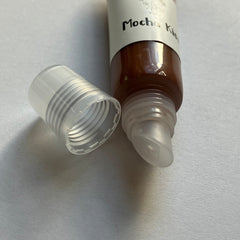 Mocha lip gloss tube with brown liquid, clear cap, and "Mocha Kiss" text
