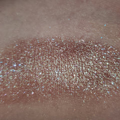 Side view of fan art inspired eye shadow palette showcasing vibrant multicolor shades in sleek rectangular compact