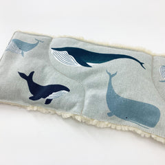 Whale print fabric with blue whales on light blue fabric with white fluffy trim