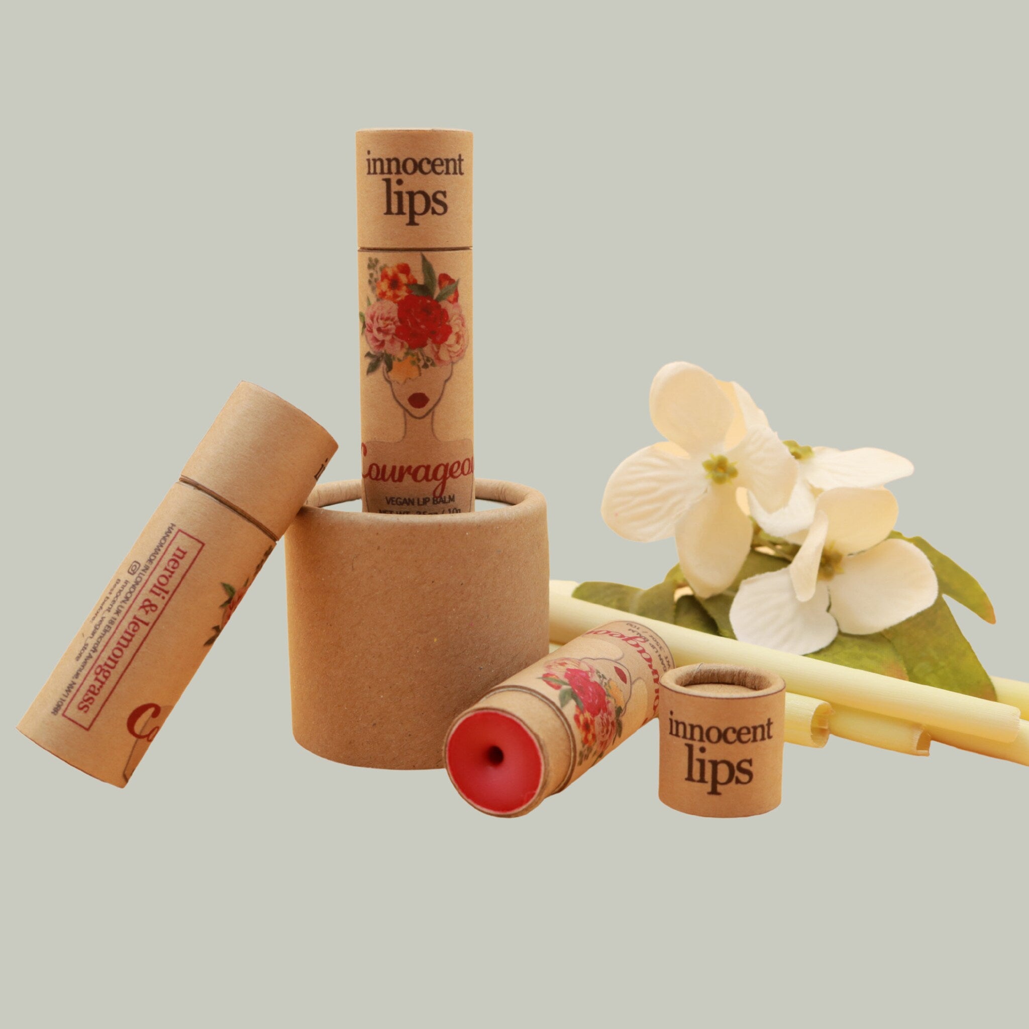 Lip balm tubes, brown cardboard, floral design, "innocent lips" text visible