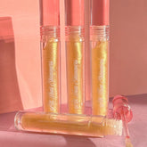 Lip gloss tubes with gold shimmer, pink cap, and "All That Shimmers" text, by PinkishPurrple